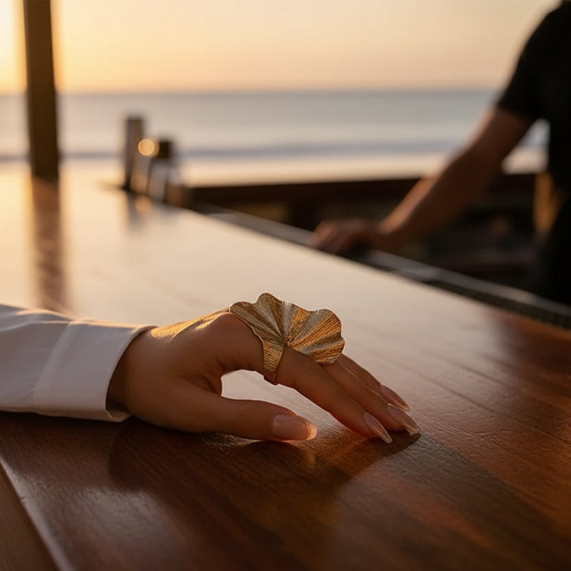 Model, wearing an oversized leaf ring by a bar in Cuba at Sunset. 