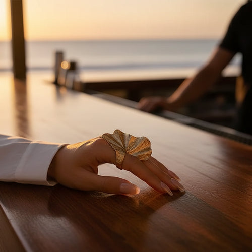 Model, wearing an oversized leaf ring by a bar in Cuba at Sunset. 
