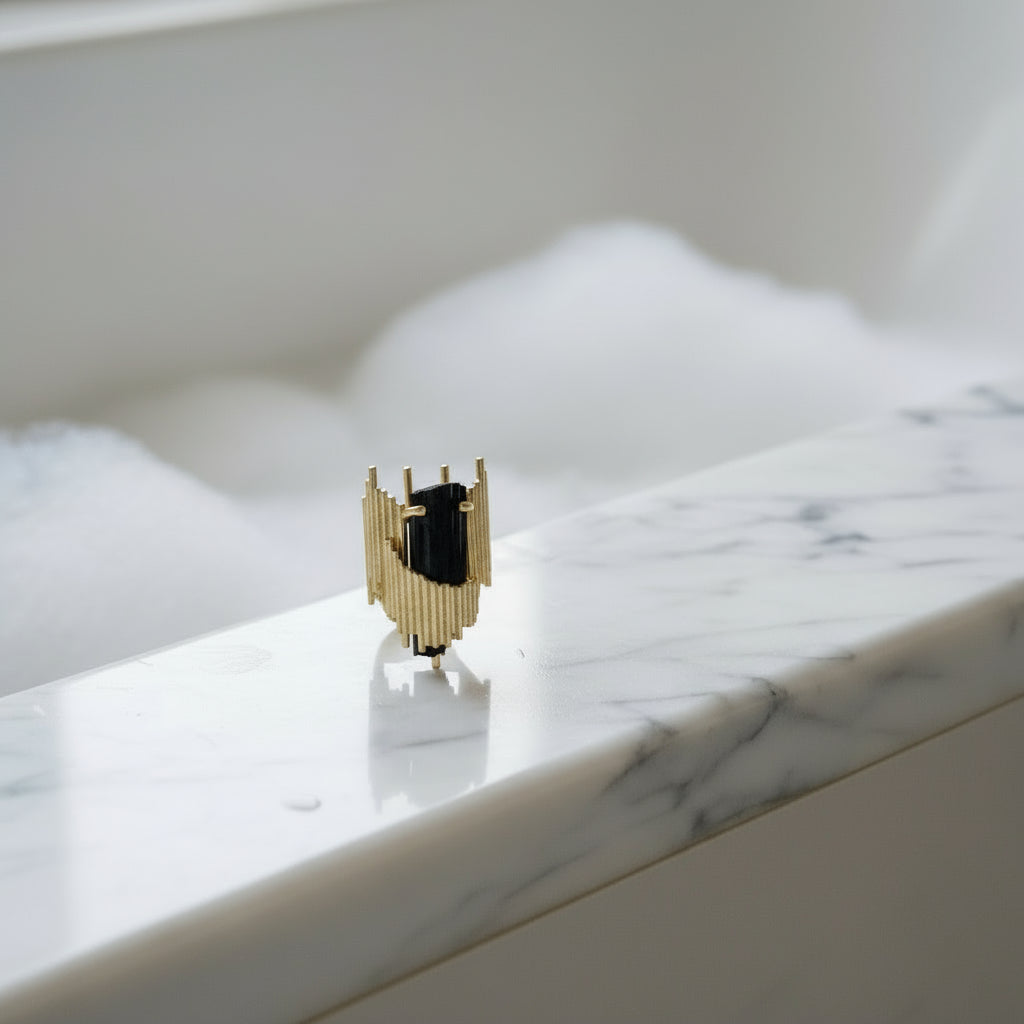 Pair of gold and black earrings on a white background